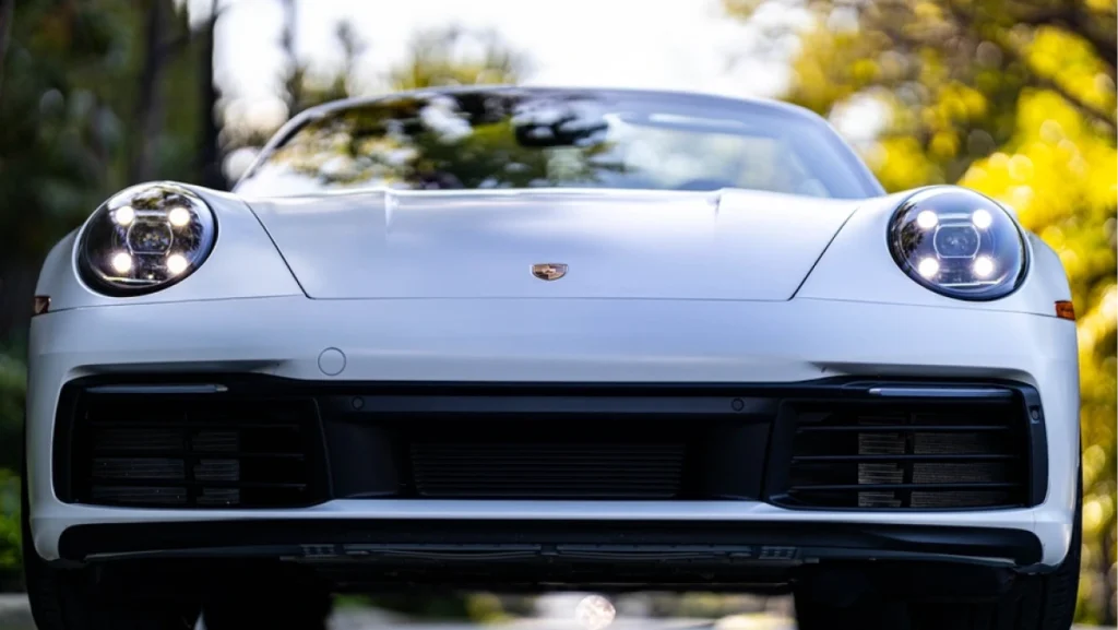 A sleek white Porsche 911 luxury car with LED headlights